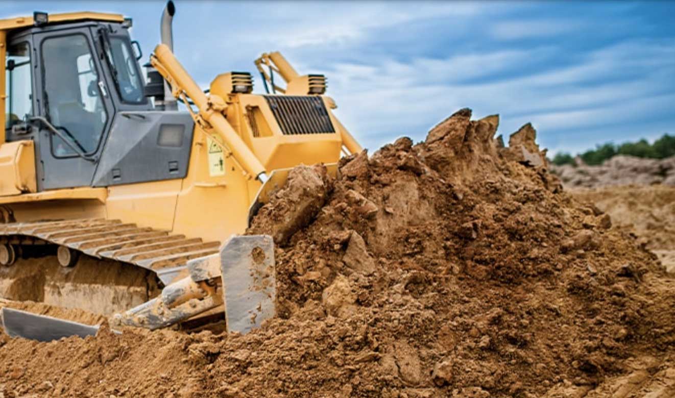 A construction vehicle moving mounds of dirt